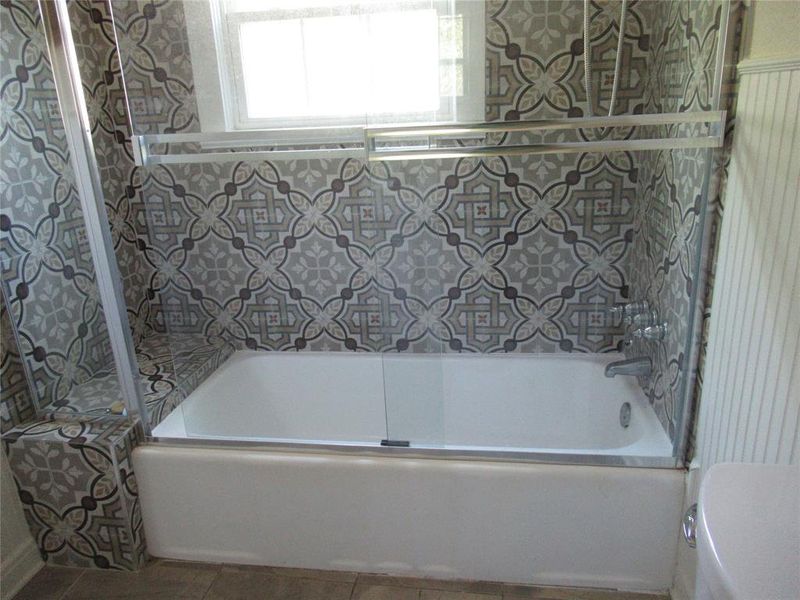 Bathroom with tile patterned floors, toilet, and shower / washtub combination