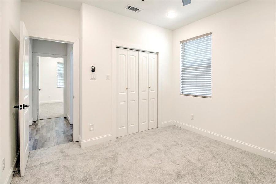 Unfurnished bedroom featuring a closet, carpet floors, and ceiling fan