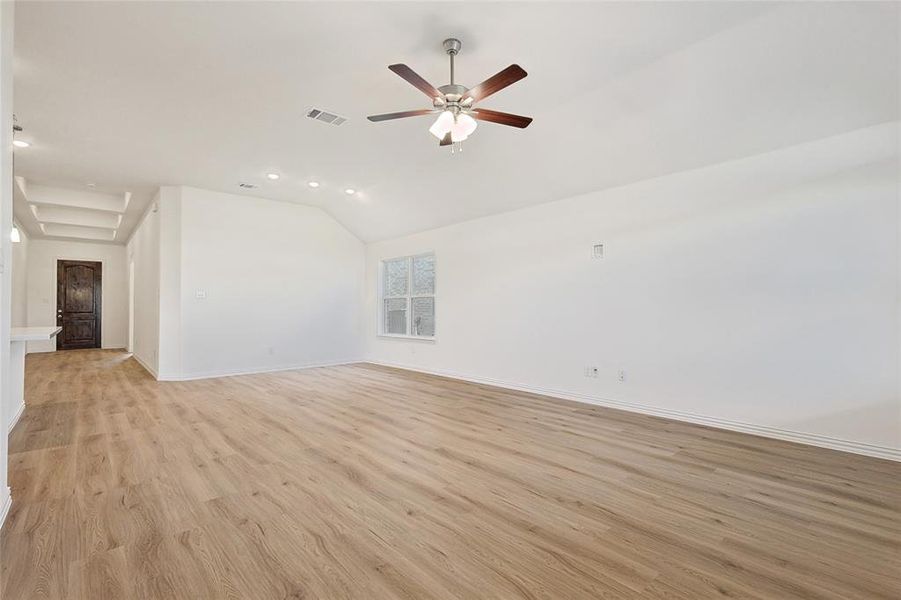 Unfurnished living room with ceiling fan, lofted ceiling, and light hardwood / wood-style floors