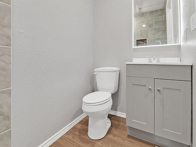 Bathroom with vanity, a shower, hardwood / wood-style floors, and toilet