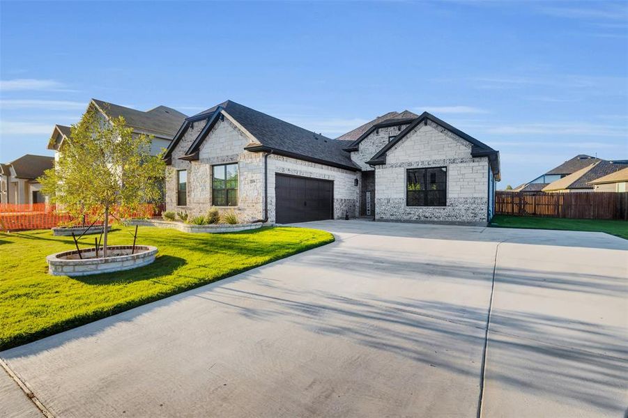 View of front of home with a front yard and a garage