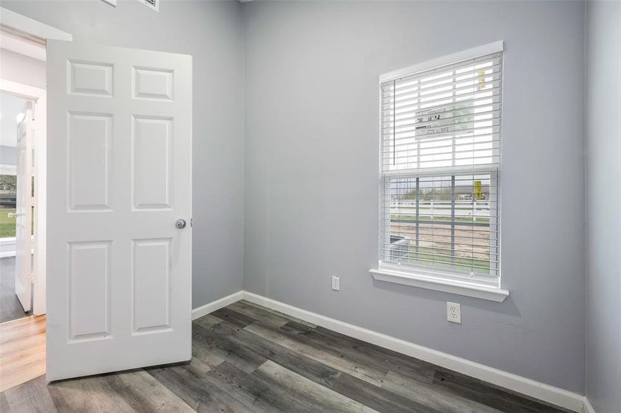 Spare room featuring a wealth of natural light and dark hardwood / wood-style floors