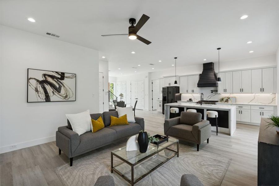 Living room featuring sink, light hardwood / wood-style flooring, and ceiling fan