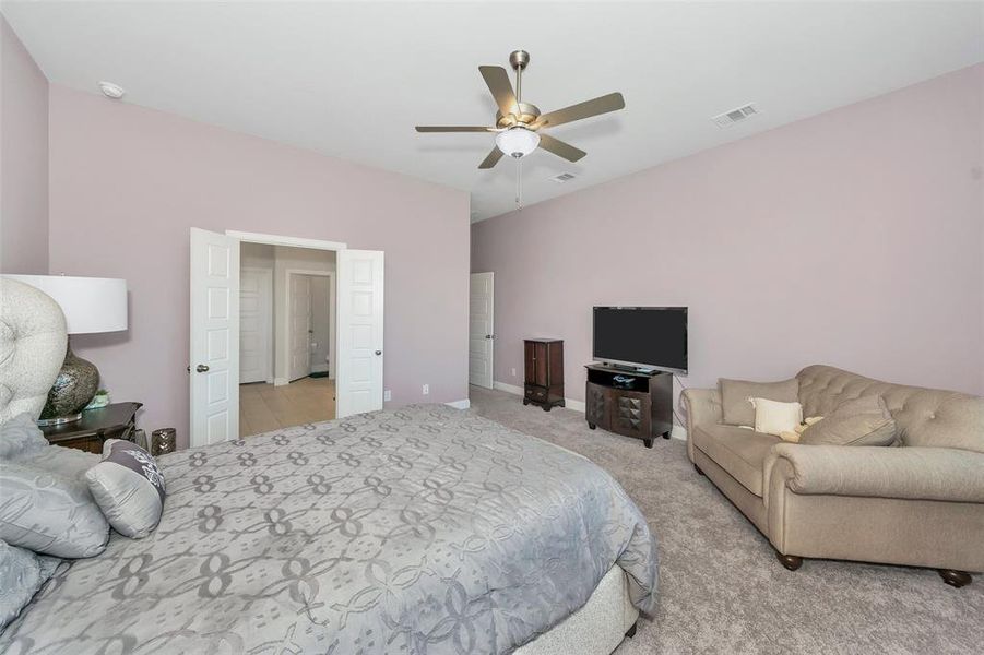 Carpeted bedroom featuring ceiling fan