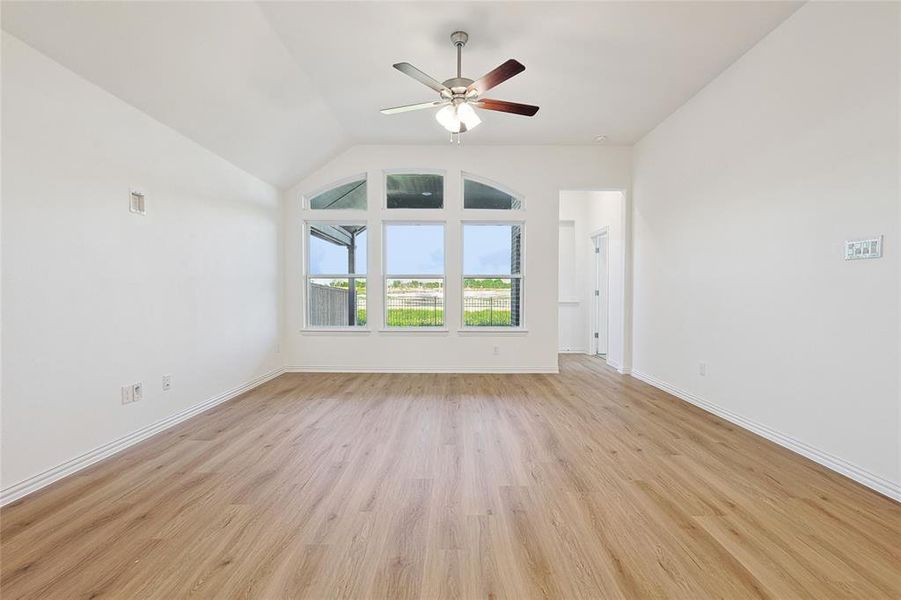 Unfurnished living room featuring ceiling fan, vaulted ceiling, and light hardwood / wood-style floors