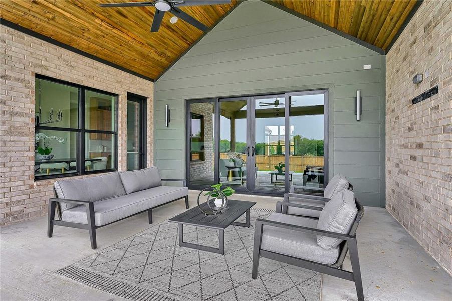 Spacious back patio accented with cedar planking and ceiling fan