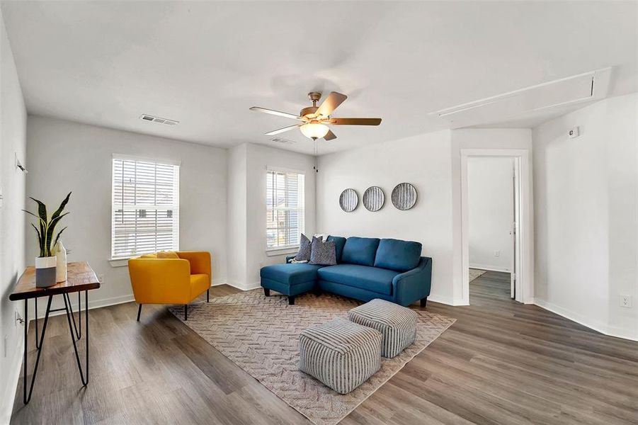 Living room featuring ceiling fan, hardwood / wood-style flooring, and a wealth of natural light