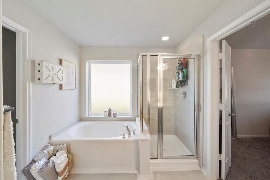 Primary bath boasts a large soaking tub and separate shower.