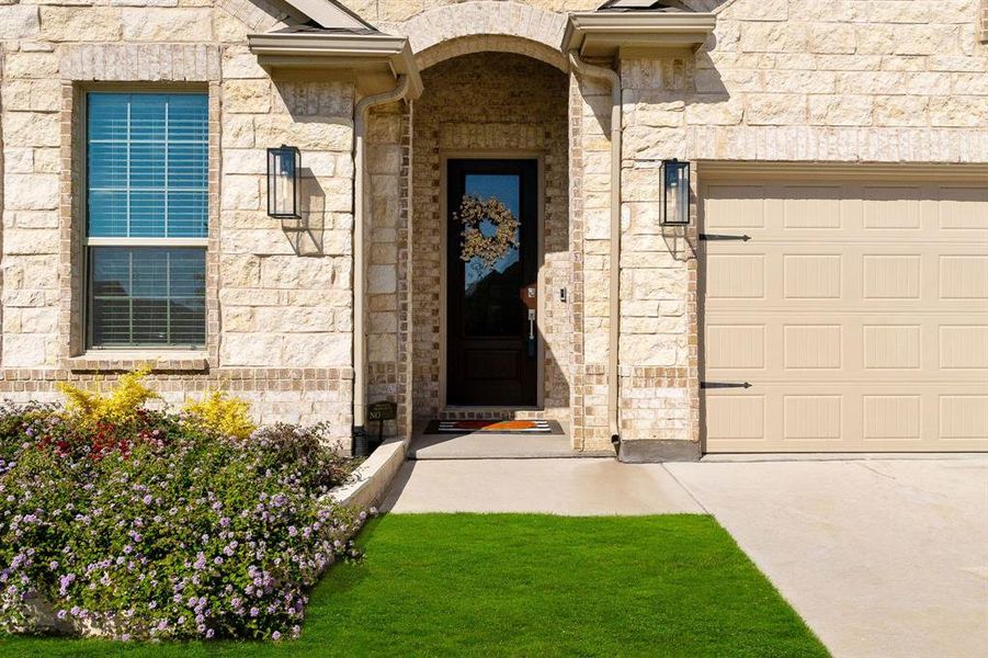 Property entrance featuring a yard and a garage