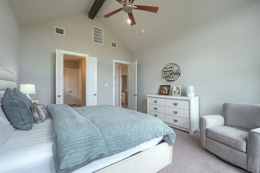 Bedroom with beamed ceiling, ceiling fan, light colored carpet, and high vaulted ceiling