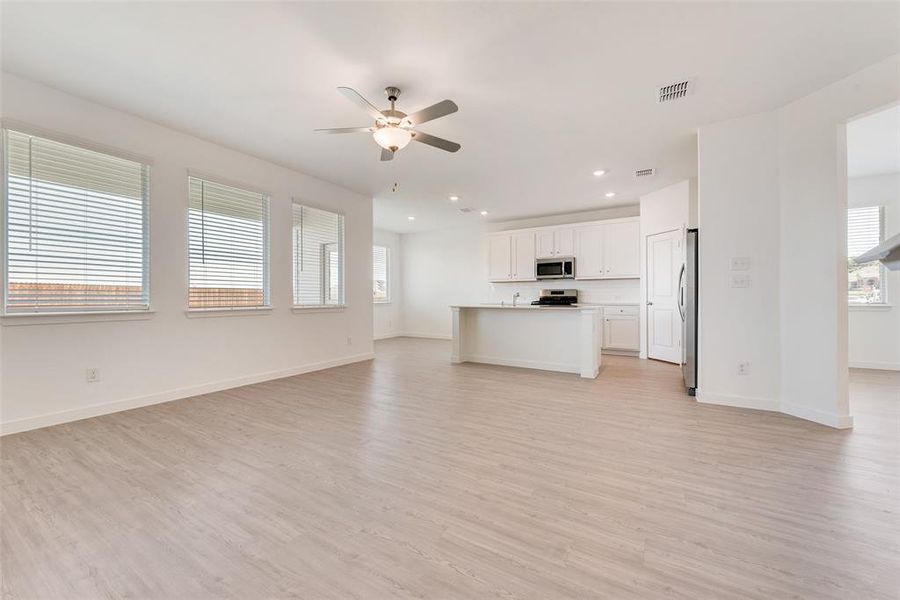 Unfurnished living room featuring light wood-type flooring and ceiling fan