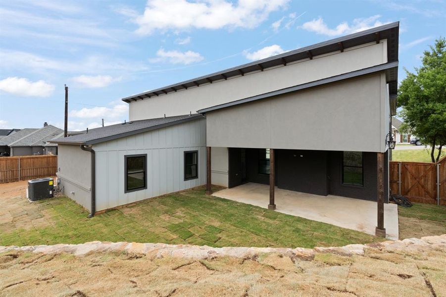 Rear view of house with a patio area, central AC, and a lawn