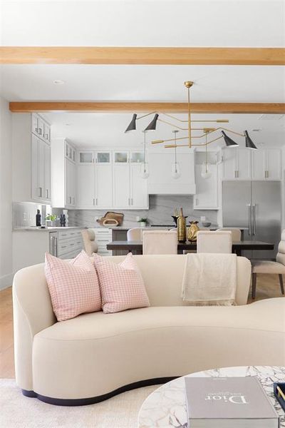 Living room with an inviting chandelier and beam ceiling