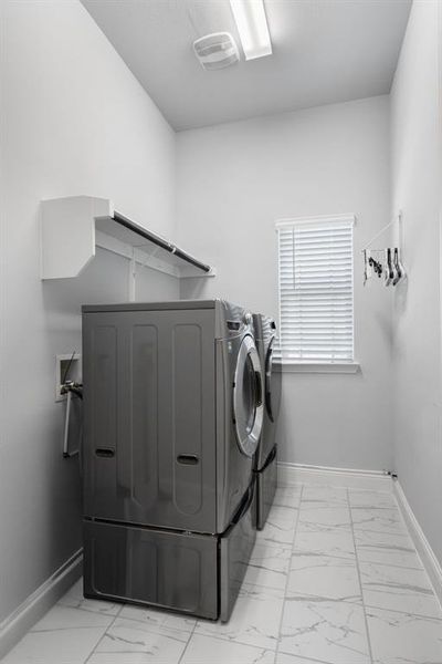 Laundry room with tiled flooring and a window