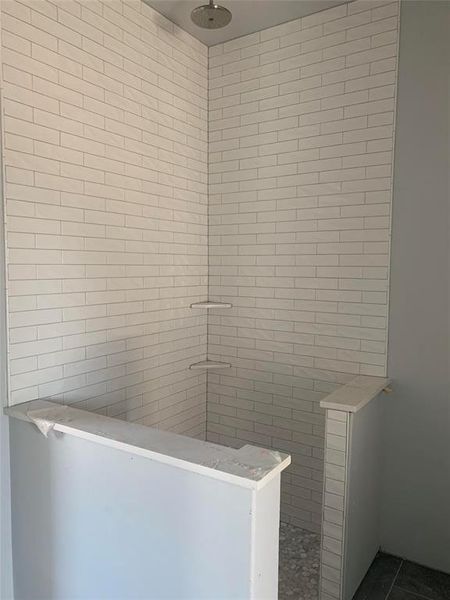 Bathroom with a tile shower and tile patterned floors