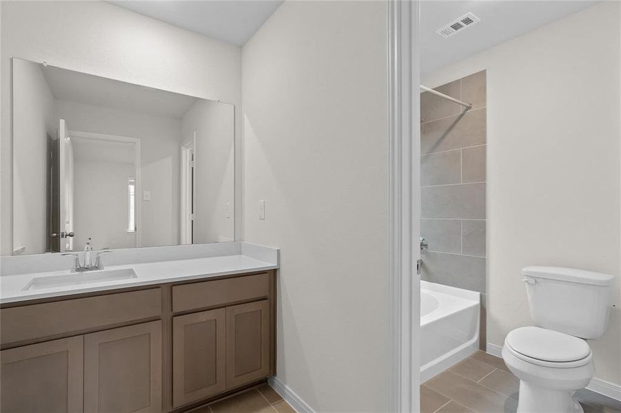 Experience modern simplicity in this well-appointed bathroom, featuring a large vanity with ample storage and a clean, crisp design. The adjacent shower and bathtub combination offer both convenience and comfort, creating a functional space that's perfect for everyday use. **This image is from another Saratoga Home with similar floor plan and finishes, not the Brayden floorplan.**