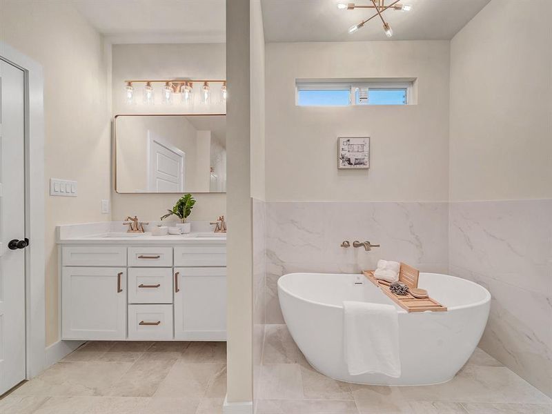 Bathroom featuring a bath, tile walls, and vanity