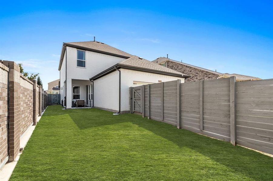 Rear view of property with a yard