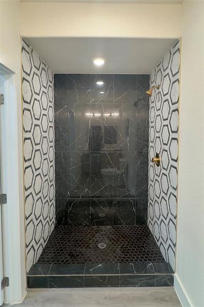 Bathroom featuring wood-type flooring and tiled shower