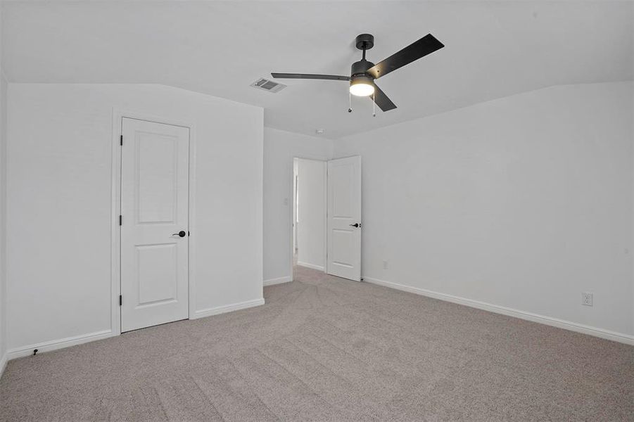 Unfurnished bedroom with lofted ceiling, light colored carpet, and ceiling fan