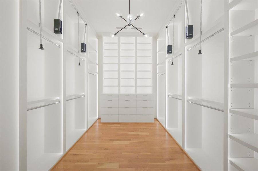 The primary closet is extensive and offers floor to ceiling built-in storage, recessed lighting in the ceiling and LED lighting in each of the built-in spaces.