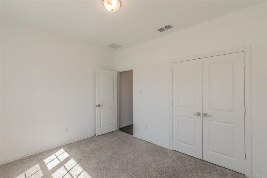 Unfurnished bedroom featuring light colored carpet and a closet