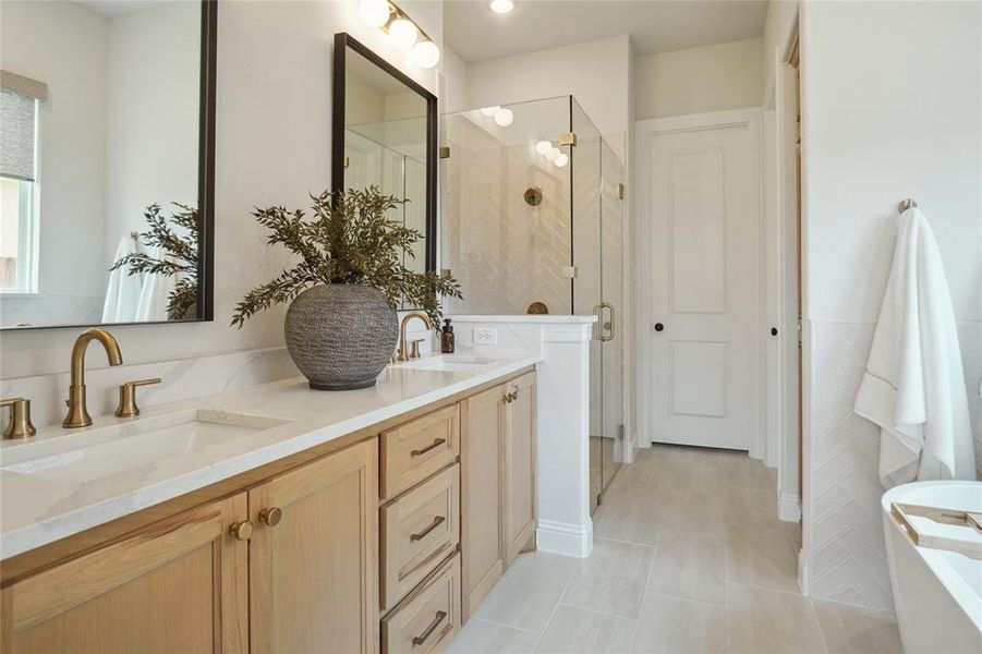 Bathroom with tile patterned flooring, separate shower and tub, and double sink vanity