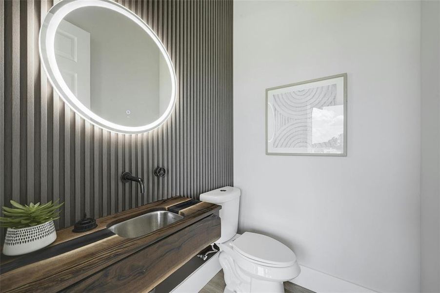 Powder room features hand crafted walnut and epoxy vanity floating on slat wall.