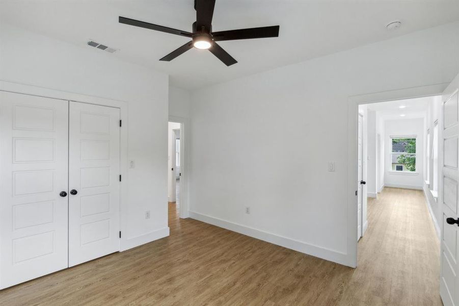 Unfurnished bedroom with ceiling fan, light hardwood / wood-style flooring, and a closet