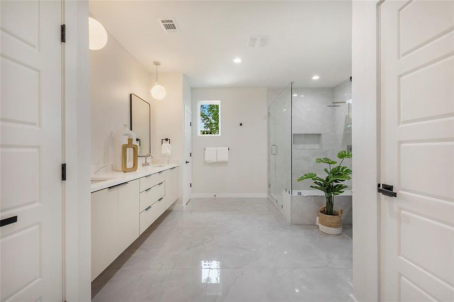Bathroom with tile patterned floors, an enclosed shower, and dual bowl vanity