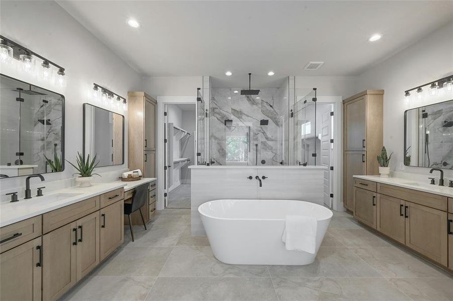 The stunning primary bathroom features 2 large separate vanity spaces, ample storage, custom cabinetry, dual shower heads, body spray, rain shower, and oversized free standing soaking tub.