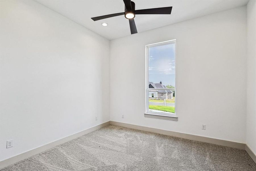 Carpeted empty room featuring ceiling fan