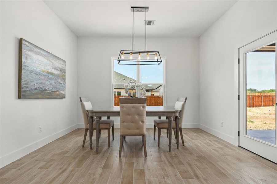 Dining area featuring light hardwood / wood-style floors and a notable chandelier