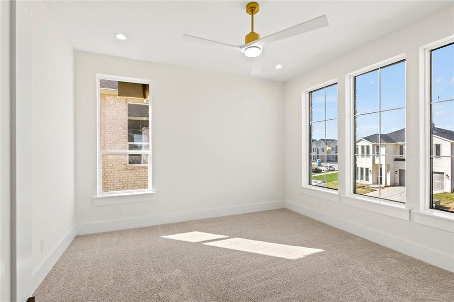 Carpeted spare room with ceiling fan