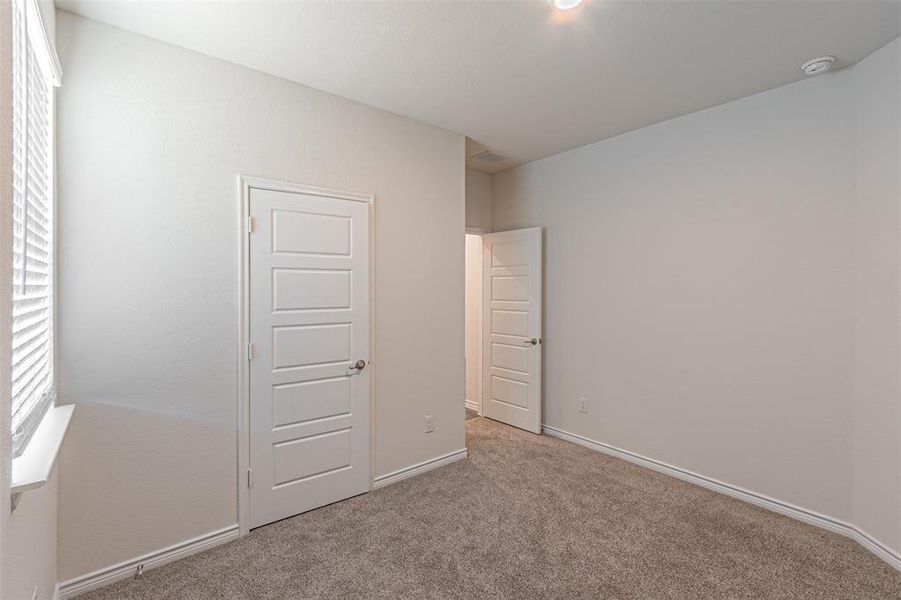 Unfurnished bedroom featuring light colored carpet