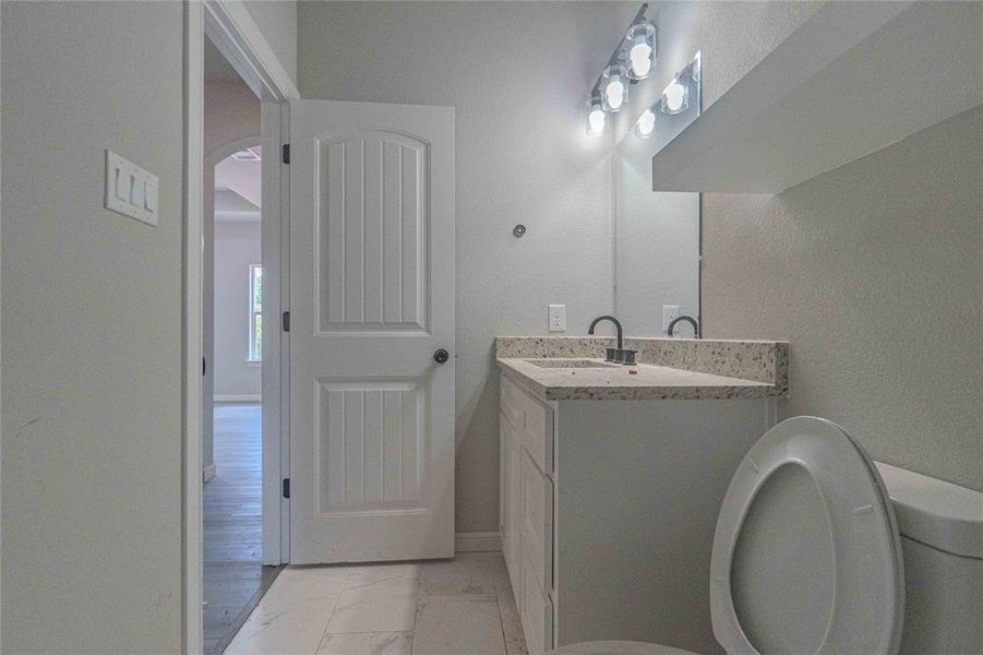 Bathroom featuring hardwood / wood-style flooring, vanity, and toilet