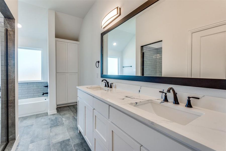 Bathroom with vanity, lofted ceiling, plus walk in shower, and a healthy amount of sunlight