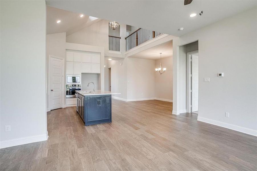 Kitchen featuring white cabinets, an island with sink, sink, stainless steel appliances, and light hardwood / wood-style floors