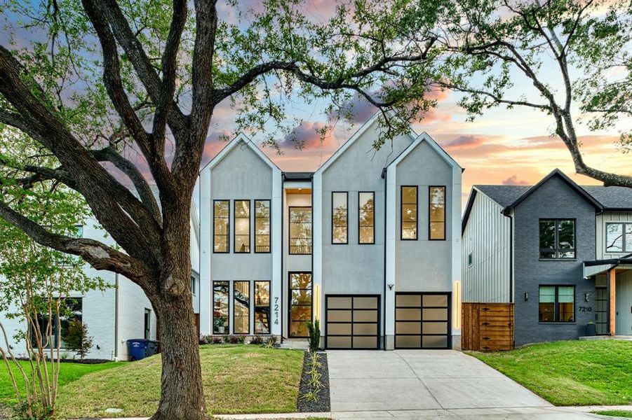 View of front of property with a garage and a yard