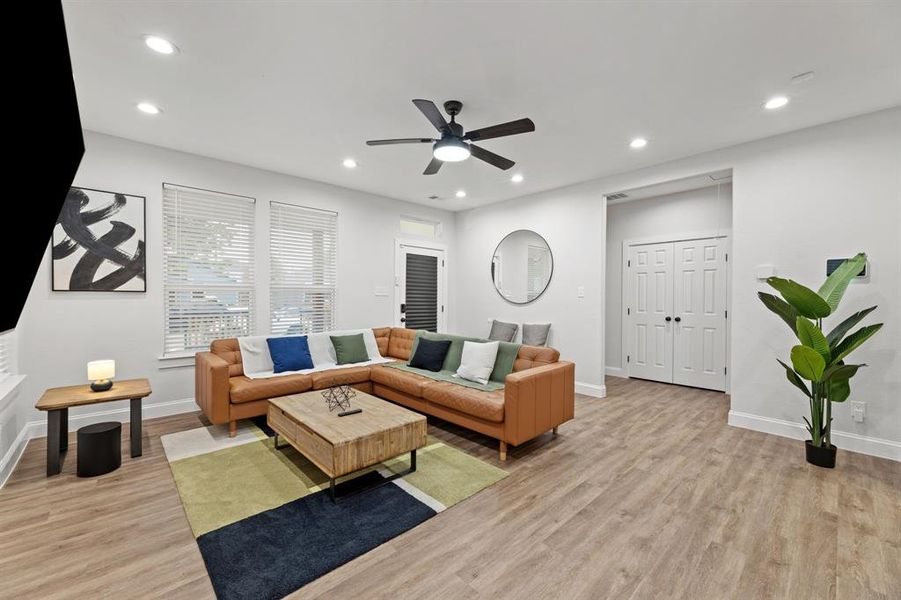 Living room with ceiling fan and light wood-type flooring