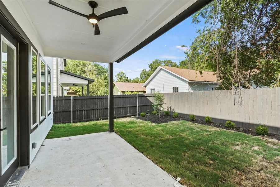 View of yard with ceiling fan and a patio