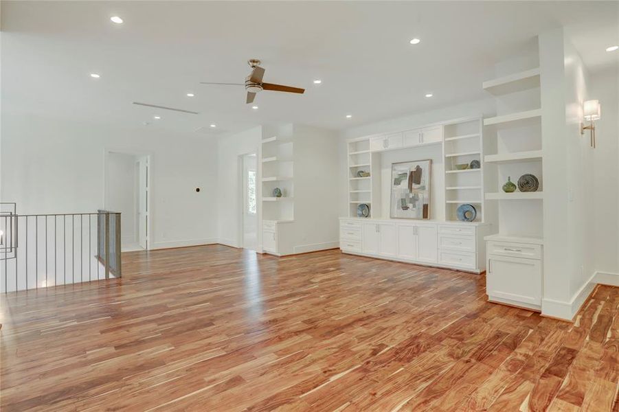 Large Game Room with elegant Brazilian Walnut floors and a wall of built-ins.