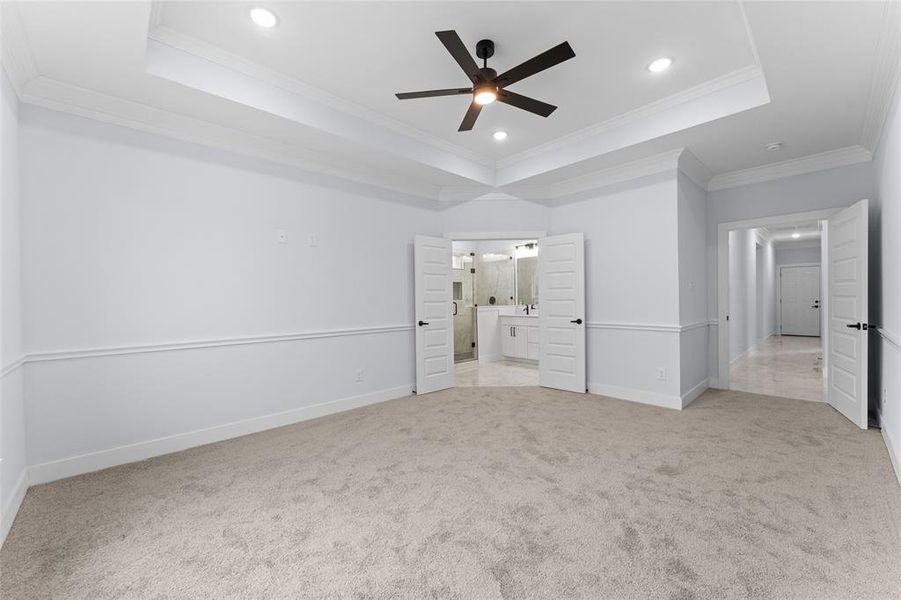 Unfurnished bedroom with ornamental molding and a tray ceiling