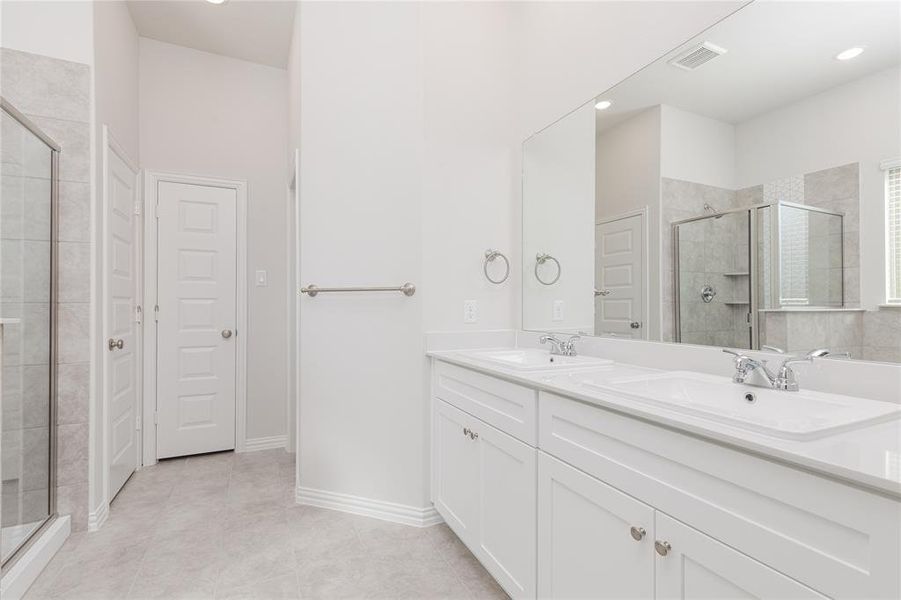 Bathroom with vanity, tile patterned flooring, and an enclosed shower