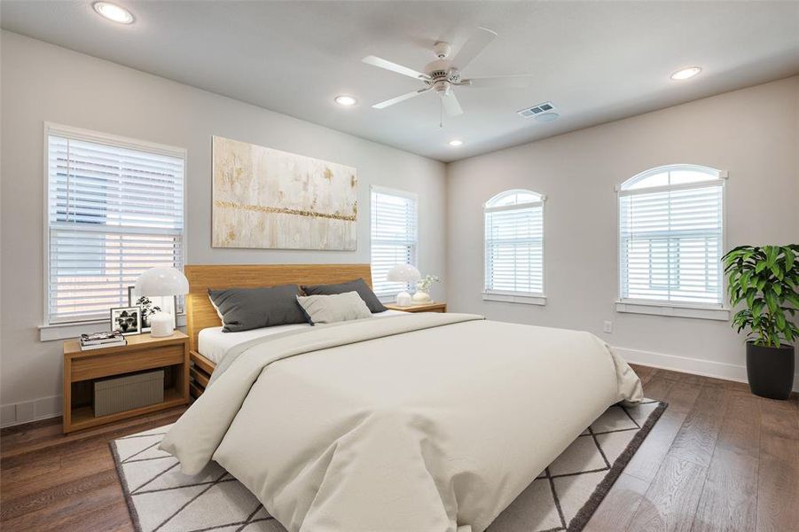 Primary bedroom with hardwood floors and a ceiling fan