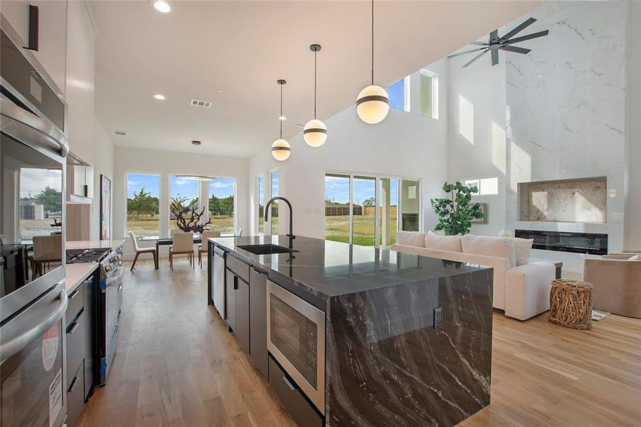 Kitchen with a center island with sink, stainless steel appliances, and plenty of natural light