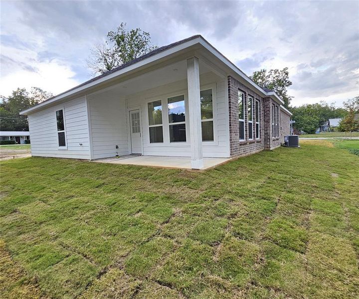 Back covered patio, a lawn.