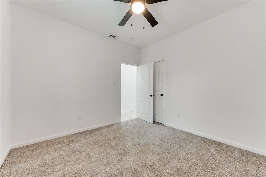 Empty room featuring light colored carpet and ceiling fan