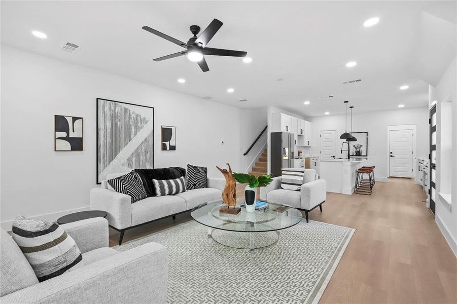 Living room with ceiling fan and light wood-type flooring