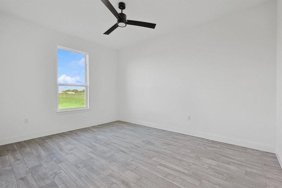 Unfurnished room with ceiling fan and light hardwood / wood-style floors